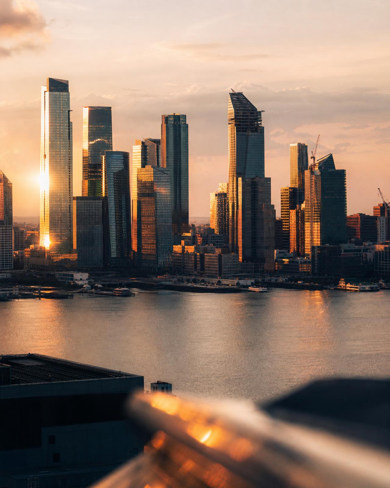 A modern global city skyline at golden hour, seen from across the water — warm light on glass towers suggesting momentum and forward movement